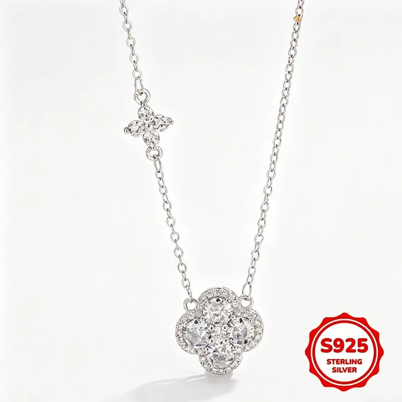 Sterling silver necklace featuring a four-petal flower pendant and a small butterfly charm on a delicate chain, shown on a white background with an S925 sterling silver badge.
