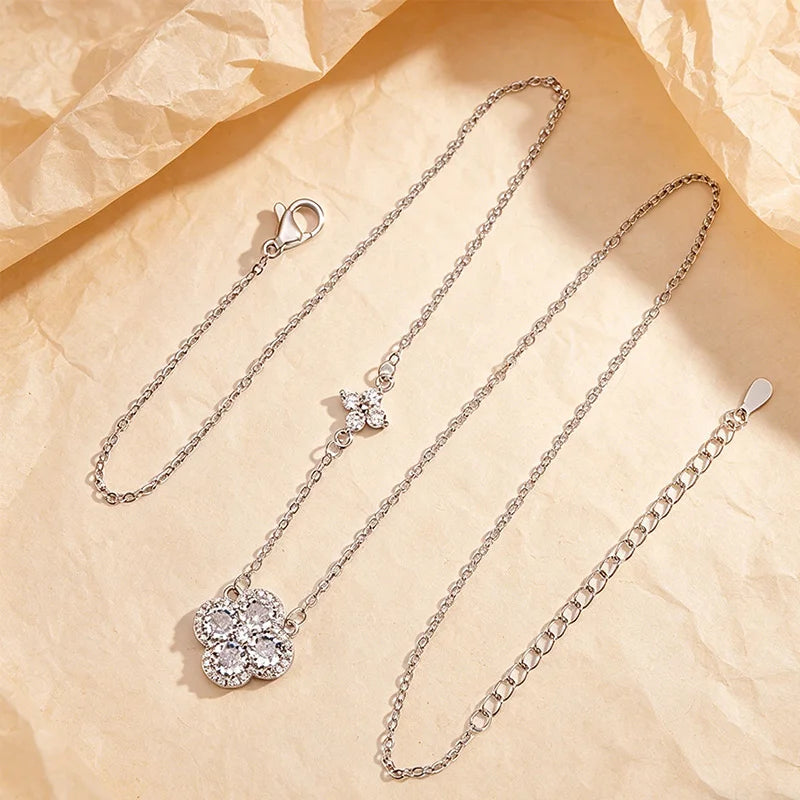 Silver necklace with floral pendants on a beige textured background
