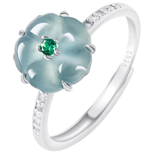 Silver ring with a green gemstone and diamond accents on a white background